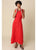 Woman wearing a red sleeveless dress against a beige background