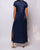 Navy blue satin dress with a back slit on a white background