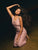 Woman in a pink dress with flowing hair against a dark background