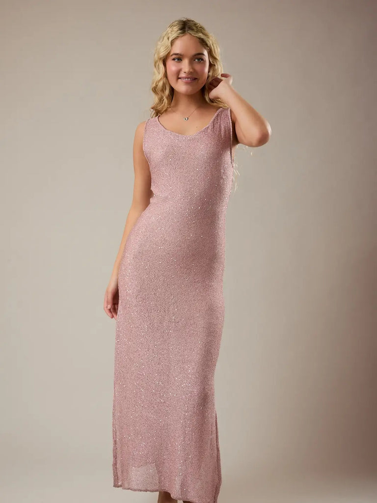 Woman wearing a pink dress against a plain background